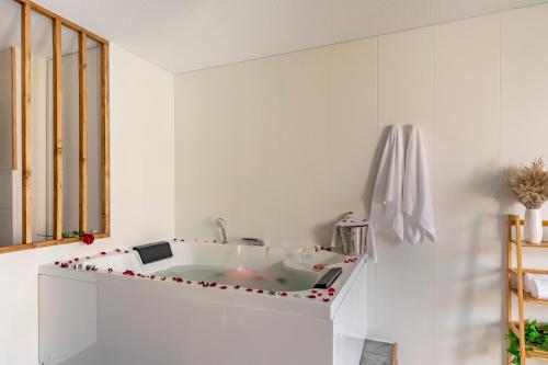 a white kitchen with a bath tub in a room at Bali Chic in La Hourcade