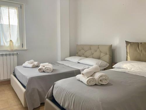 2 camas con toallas en una habitación en B&B Sabbia e Sassi, en Praia a Mare