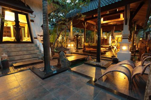 um alpendre de uma casa com uma estátua em KhgeMa NuanJun Pool Villa Gallery Resort em Ban Huai Yai