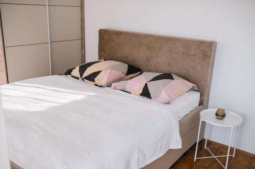 a bedroom with a white bed with a headboard and a stool at Ferienhaus in Široki Brijeg