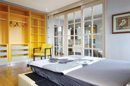 1 dormitorio con 1 cama grande y 1 silla amarilla en Lavish Retreat: Stylish & Scenic Penthouse, en Johor Bahru
