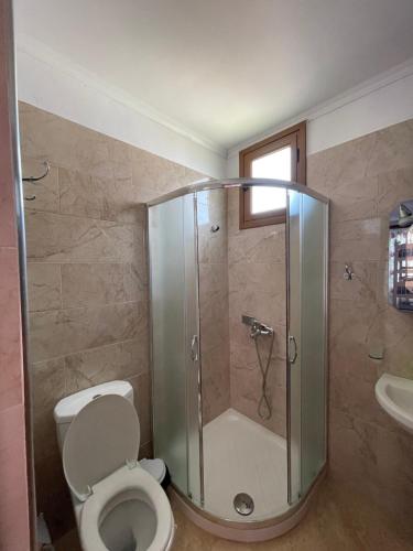 a bathroom with a shower with a toilet and a sink at Garden Villa Veli in Ksamil