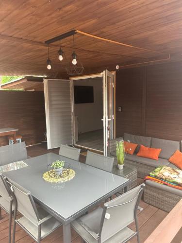 a dining room with a table and a couch at Domek Wakacyjny Monika 30 in Głębokie