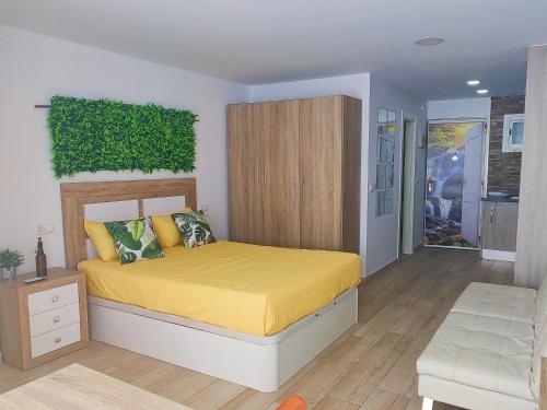um quarto com uma cama amarela e uma parede verde em Deluxe Studio Hercules em Benalmádena