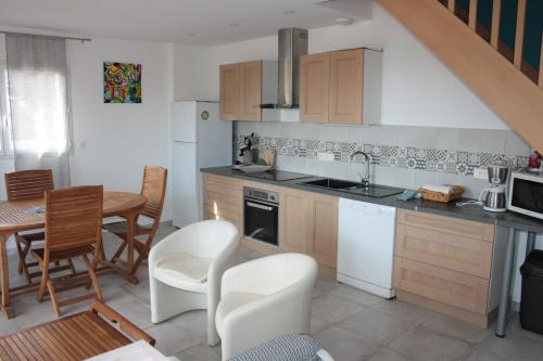 une cuisine et une salle à manger avec une table et des chaises dans l'établissement Gite du Llevan, à Sorède