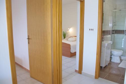 a bathroom with a toilet and a bed in a room at SeaSide VARSAN in Borovići