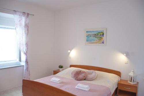 a bedroom with a bed with two pillows on it at SeaSide VARSAN in Borovići