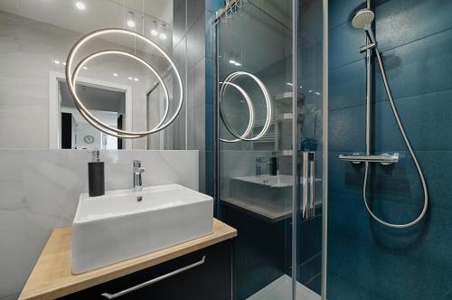 y baño con lavabo y ducha. en Apartamenty MM - Rzeźniczaka, en Zielona Góra