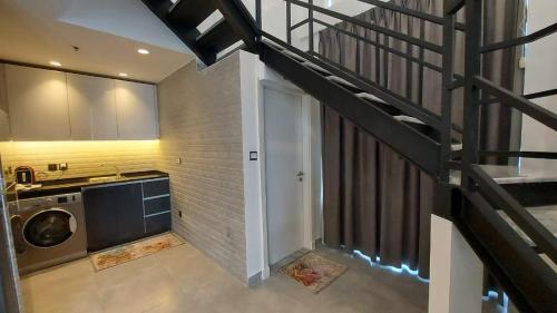 a staircase leading up to a laundry room with a door at Furnished apartment in Damac Tower. Jordan in Amman