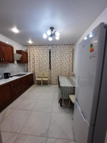uma cozinha com uma mesa e um frigorífico em Жк Сити плюс em Almaty