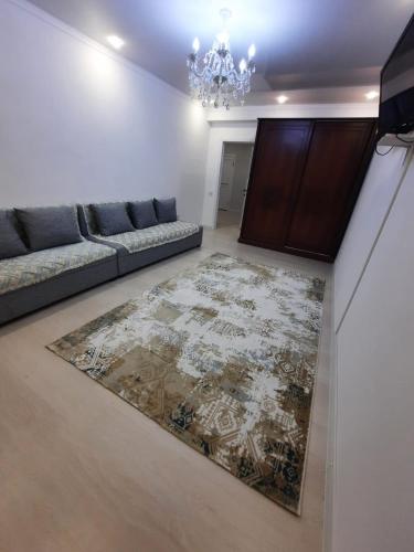 uma sala de estar com um sofá e um tapete em Жк Сити плюс em Almaty