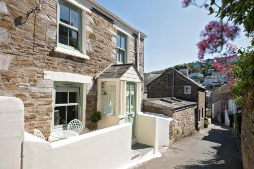 a stone house with a green door on a street at Enchanting Harbourside Cottage with Panoramic Views in Polruan