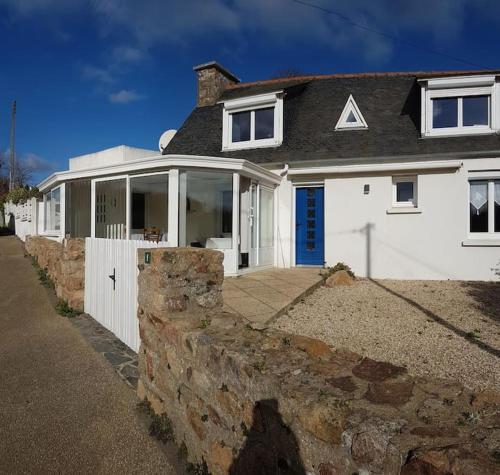 une maison blanche avec un mur en pierre dans l'établissement La maison aux Hortensias, 1km de la plage, proche du sillon de Talbert, à Pleubian