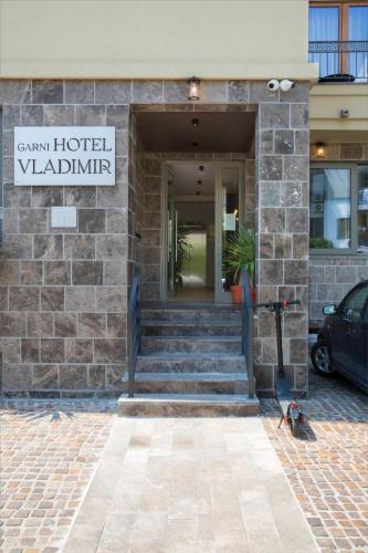 a hotel building with stairs and a sign on it at Hotel Vladimir in Budva