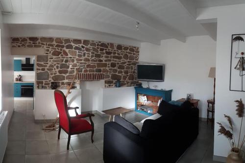 un salon avec un canapé et une cheminée dans l'établissement La maison aux Hortensias, 1km de la plage, proche du sillon de Talbert, à Pleubian