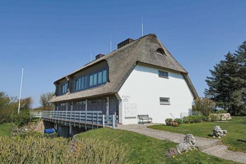 a house with a thatched roof on top of it at Wattkoje-Ein-Appartement-der-besonderen-Art-erwartet-Sie-am-Rande-der-Braderuper-Heide in Braderup