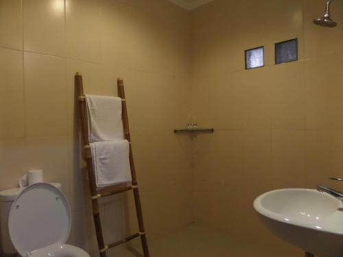 a bathroom with a toilet and a sink at Mansu Hotel and Spa Legian in Kuta