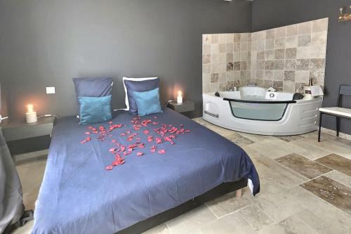 een slaapkamer met een bed en een bad met bloemen erop bij Appartement Balnéo in Villeneuve