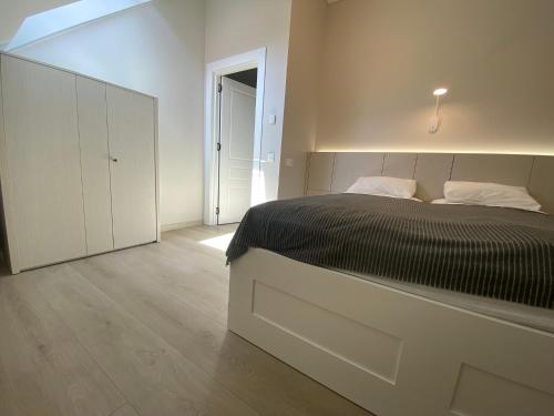 a bedroom with a black and white bed and a closet at Urbas Sea view apartment in Nida