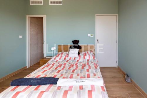 a bedroom with a large bed with a person sitting on it at Villa Vue Mer, Piscine & Plage à 6Min in Cagnes-sur-Mer