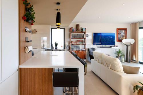 an open kitchen and living room with a white counter top at Villa Vue Mer, Piscine & Plage à 6Min in Cagnes-sur-Mer