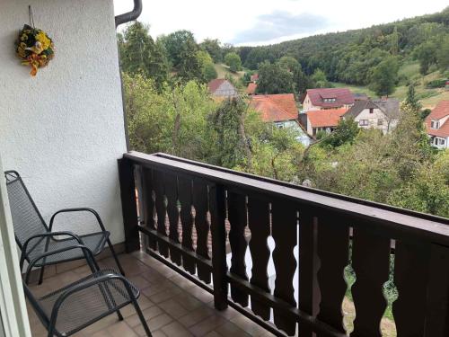 a balcony with two chairs and a view of a valley at Gästehaus Lützelbach in Lützelbach