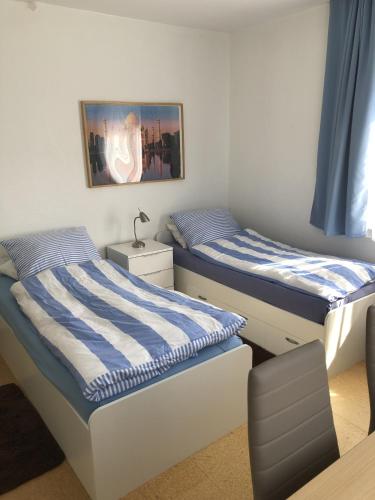 two twin beds in a room with blue curtains at Gästehaus Lützelbach in Lützelbach