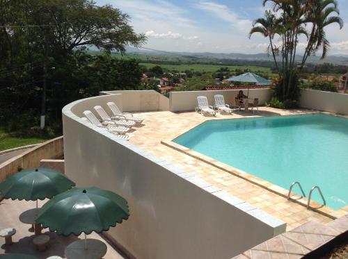 a swimming pool with chairs and umbrellas on a house at Maison Clapp in Penedo