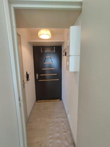 un couloir avec une porte noire dans une chambre dans l'établissement Studio Cosy Les Myrtilles P2000, à Bolquère-Pyrénées 2000