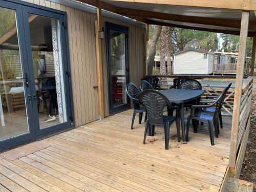 a patio with a table and chairs on a deck at Camping 4 étoiles Le Bosc Saint Cyrpien Mobil Home in Saint-Cyprien