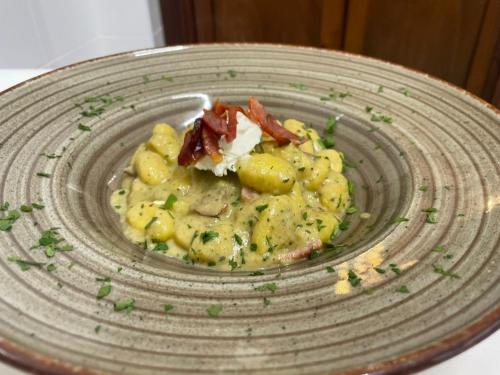 a plate of food with potatoes and bacon on it at Agriturismo l'Olivo in Calatafimi