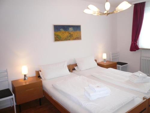 1 dormitorio con 2 camas con sábanas blancas y 2 lámparas en App-Hoelscher-21, en Westerland