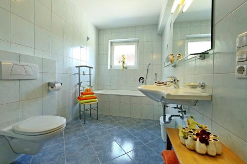 een badkamer met een toilet, een wastafel en een bad bij Alpen Appartements MOIGG in Mayrhofen