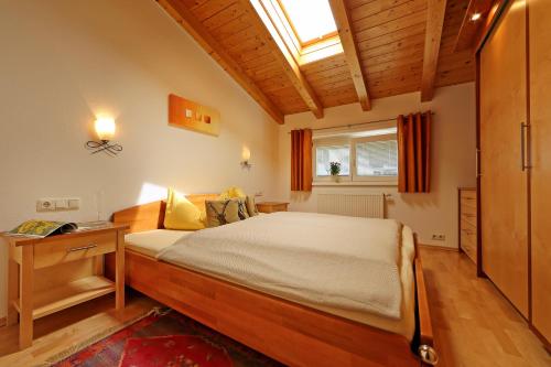 een slaapkamer met een groot bed en een raam bij Alpen Appartements MOIGG in Mayrhofen