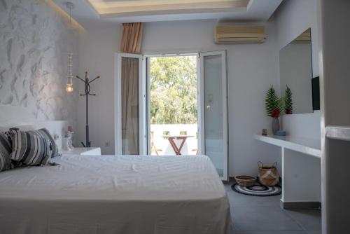 a white bedroom with a bed and a bathroom at Keti Kapri in Plaka