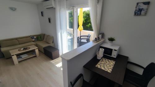 una pequeña sala de estar con sofá y mesa. en Apartment Iva&Andro, en Koločep