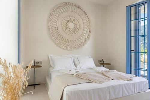 a bedroom with a white bed with a mirror on the wall at Tellion Suites in Lefkada Town