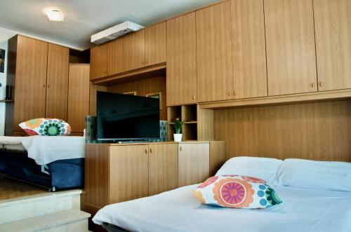 1 dormitorio con 2 camas y TV de pantalla plana en Al Sole di TSS' - Cozy Apartment a 20 Metri dal Lago di Caldonazzo - Perfetto per coppie a Calceranica al Lago, en Calceranica al Lago