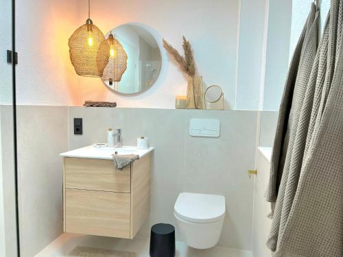 a bathroom with a sink and a toilet and a mirror at Maison Saarschleife Mettlach in Mettlach