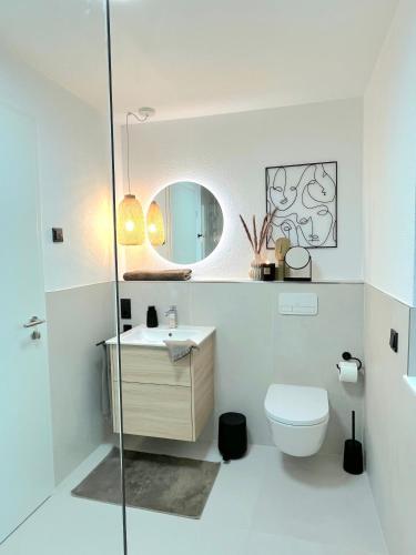 a bathroom with a toilet and a sink and a mirror at Maison Saarschleife Mettlach in Mettlach