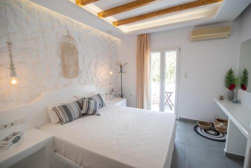 a white bedroom with a large white bed in a room at Keti Kapri in Plaka