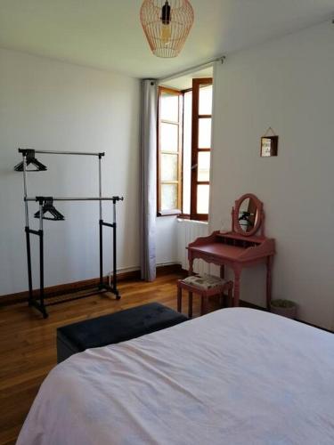 une chambre avec un lit, une table et un miroir dans l'établissement Maison charentaise, à Pons