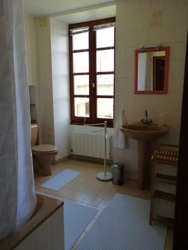 une salle de bain avec un lavabo et des toilettes et une fenêtre dans l'établissement Maison charentaise, à Pons