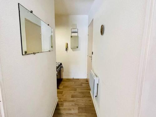un couloir avec un miroir et un mur blanc dans l'établissement Appartement T2 avec terrasse et parking à 100m de la plage d'Eyrac - Arcachon - FR-1-433-13, à Arcachon