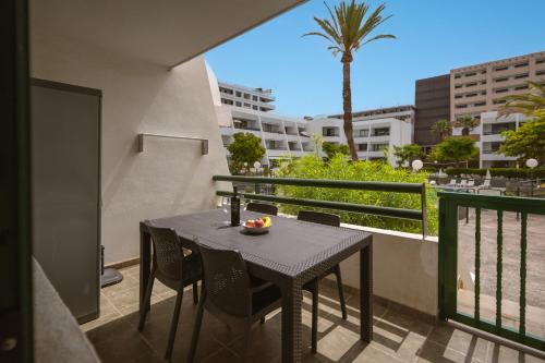 a black table and chairs on a balcony with a palm tree at GO2TENERIFE Apart'Arona City center & Beach at 5 min in Arona