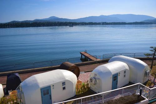 a row of white domes next to a body of water at The Gran Resort Amanohashidate in Miyazu