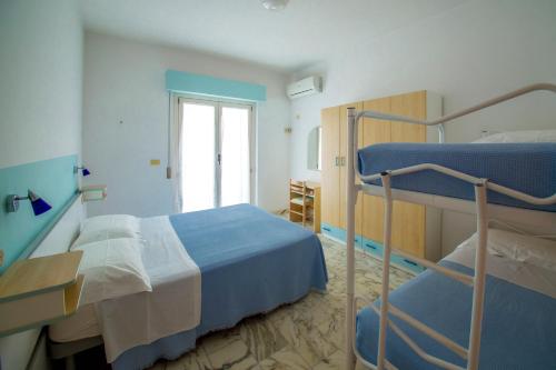a bedroom with two bunk beds and a window at Albergo Il Veliero in Pineto