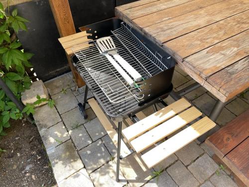 un grill assis à côté d'une table et d'un banc dans l'établissement Villa Elisabetta, à Chiusi della Verna