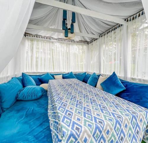 a bedroom with a blue bed in a tent at Panorama Hills in Almaty