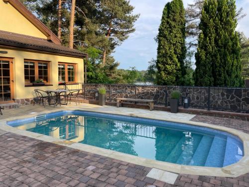 a swimming pool in a patio with a bench next to a house at Resort-Restaurant Stilec in Kamenný Újezd